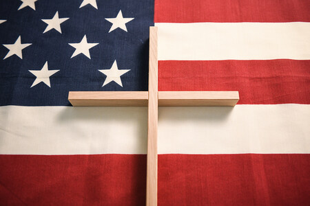 Ein helles Holzkreuz liegt auf einer US-amerikanischen Fahne am 2. Dezember 2020 in Bonn.