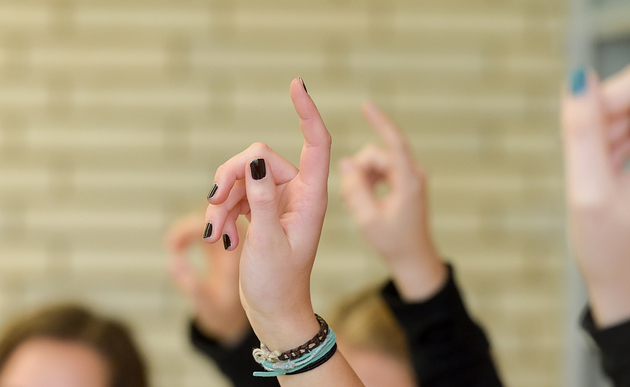 Evangelischer Religionsunterricht in einem Berufskolleg in Bonn. Schüler melden sich. Hinweis: Model-Release ist vorhanden.