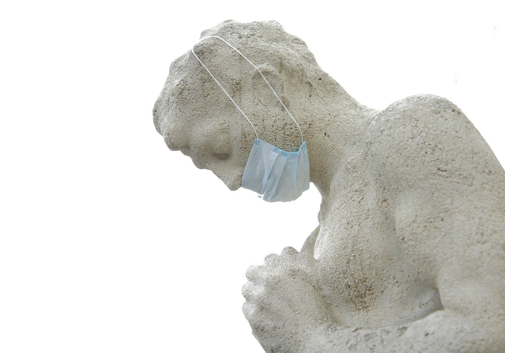                               Statue eines betenden Menschen mit Mundschutz