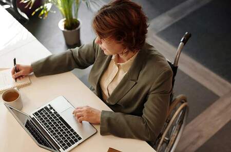 Frau am Rollstuhl bei der Arbeit