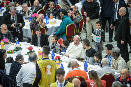 Papst Franziskus sitzt an einem Tisch bei einem Mittagessen zum Welttag der Armen am 13. November 2022 in der Synodenaula im Vatikan.