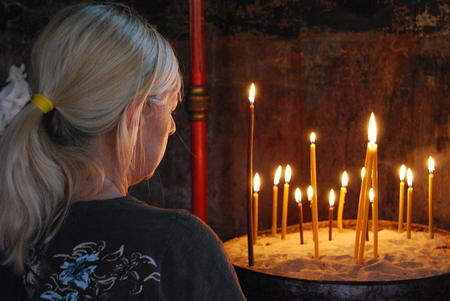 Gläubige vor Kerzen in einer orthodoxen Kirche