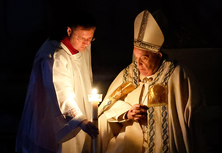 Osternacht mit Papst Franziskus / Copyright 2024, KNA GmbH, www.kna.de, All Rights Reserved, Lola Gomez Ein Messhelfer reicht Papst Franziskus zu Beginn der Osternachtsmesse im Petersdom im Vatikan am 30. März 2024 seine Kerze, die an der Osterkerze entzündet wurde.