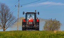 Traktor düngt mit Gülle ein Feld