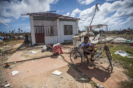 131115-N-BD107-722 GUIUAN, Eastern Samar Province, Republic of the Philippines (Nov. 15, 2013) A Guiuan resident sits in a ricksha outside of his ruined home in the aftermath of Super Typhoon Haiyan. The George Washington Carrier Strike Group support