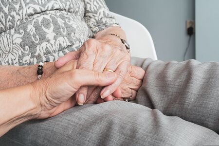 Hand hält die einer Seniorin