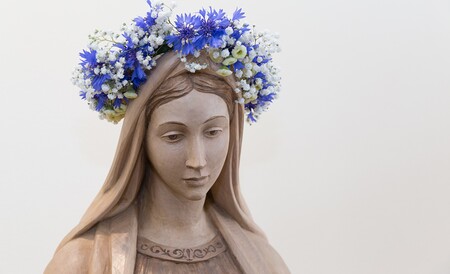 Geschnitzte Statue der Jungfrau Maria mit Blumenkranz