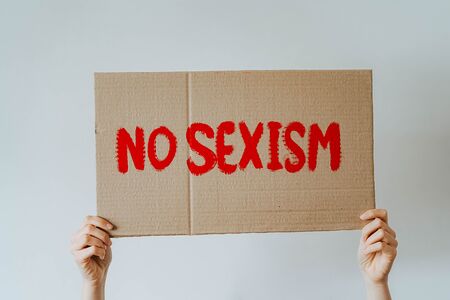 Frau hält Schild mit der Aufschrift 'No Sexism'