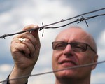Bischof Zsifkovics hinter einem Stacheldrahtzaun