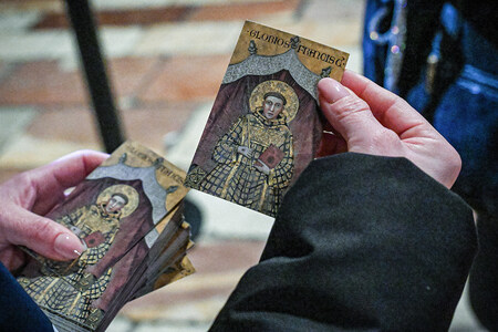 Eine Person hält Heiligenbilder des heiligen Franziskus von Assisi am 22. Februar 2026 in der Basilika San Francesco in Assisi (Italien).