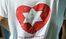 Ein freiwilliger Totengräber trägt T-Shirt mit der Aufschrift 'Lev echad' (dt. ein Herz) und darüber ein Herz mit einem Davidstern, auf dem nationalen Militärfriedhof auf dem Herzlberg in Jerusalem (Israel) am 11. Oktober 2023.